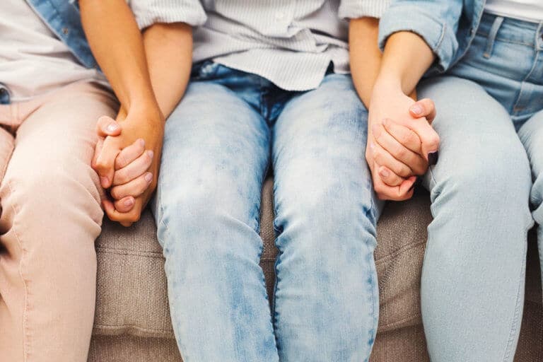 three people hold hands to represent honesty