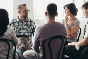 A group of people in a DUI addiction treatment program sit in a circle