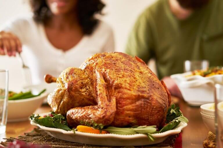 People sit at a table with a turkey talking about how to have a sober Thanksgiving