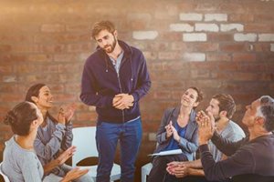 man standing in group therapy talking about what is rehab like
